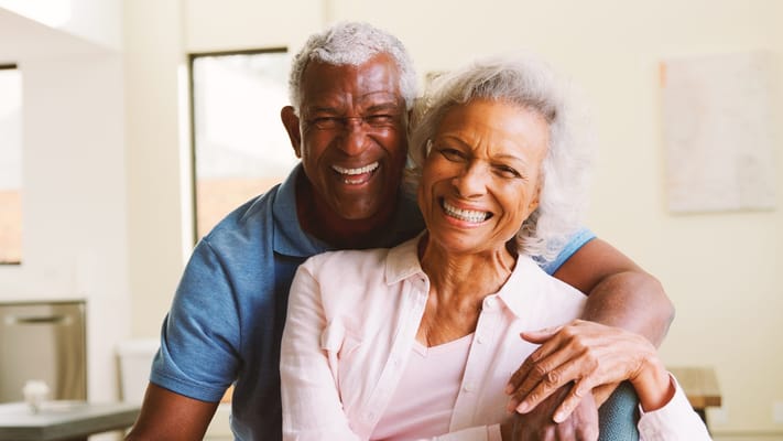 Happy senior couple smiling in a bright common area