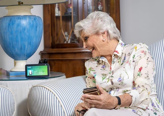 A senior woman smiling while interacting with a device