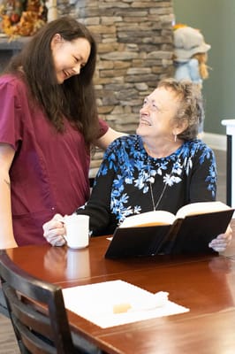 Staff member engaging with a resident in a dining area