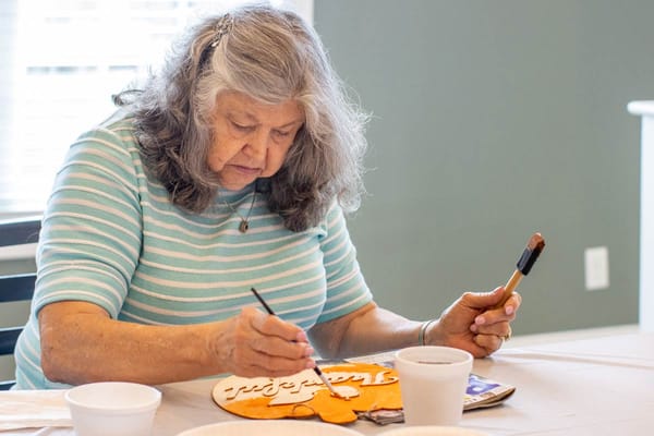 Resident engaged in an art activity at a table