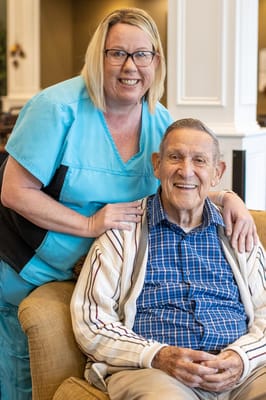 A smiling staff member with a resident in a cozy common area