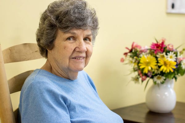 A smiling resident in a cozy indoor setting