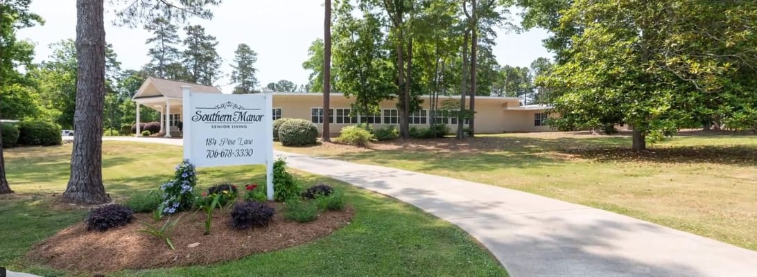 Exterior view of Southern Manor facility with sign and pathway