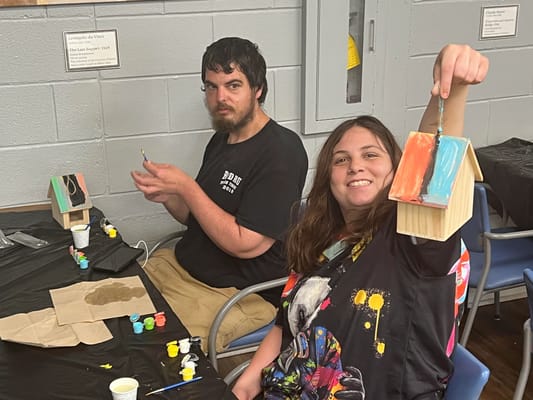 Residents engaging in a craft activity with painted birdhouses