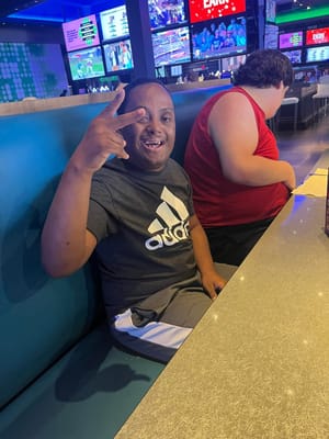 Young man smiling and making a peace sign in a casual setting