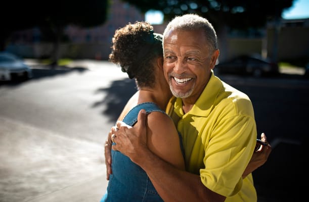 Two residents sharing a warm hug outdoors