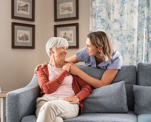 Caregiver and resident sharing a moment in a cozy living area