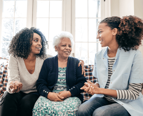 Resident interacting with staff and family in a cozy setting