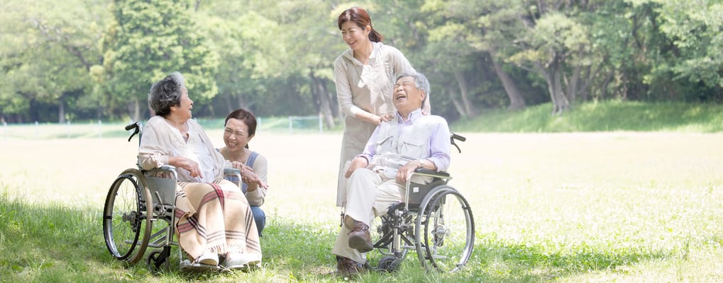 Two residents enjoying the outdoors with staff support