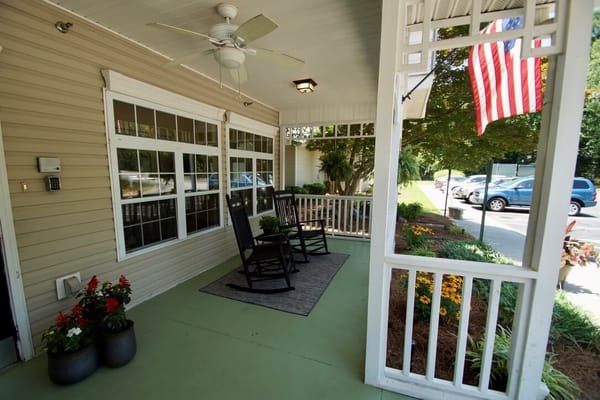 Outdoor rocking chairs on a porch with flowers
