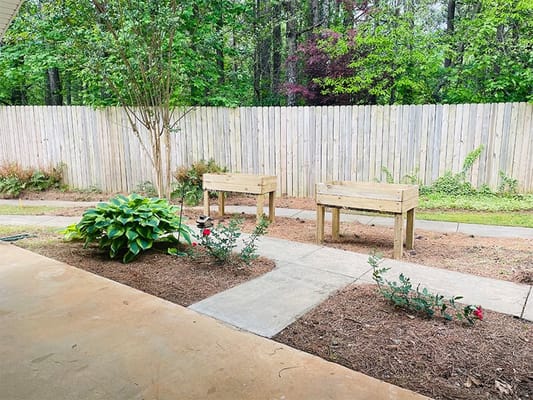 Garden area with wooden planters and green landscaping