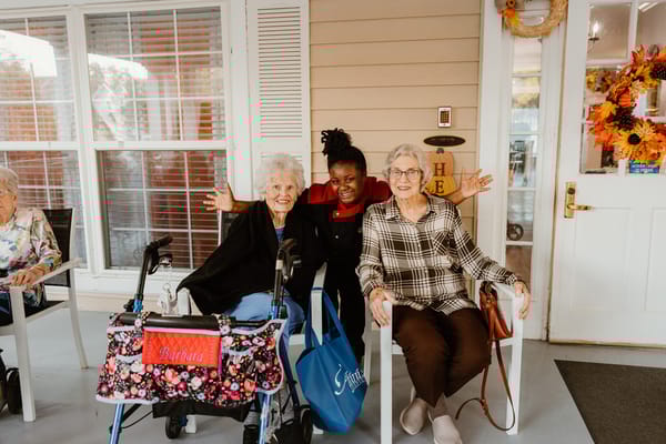 Residents posing happily with staff outside
