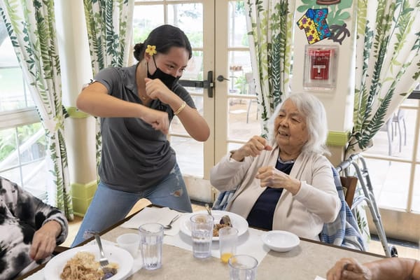 Staff and resident enjoying an activity during a meal