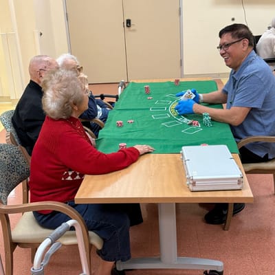 Residents enjoying a game with staff in the activity room