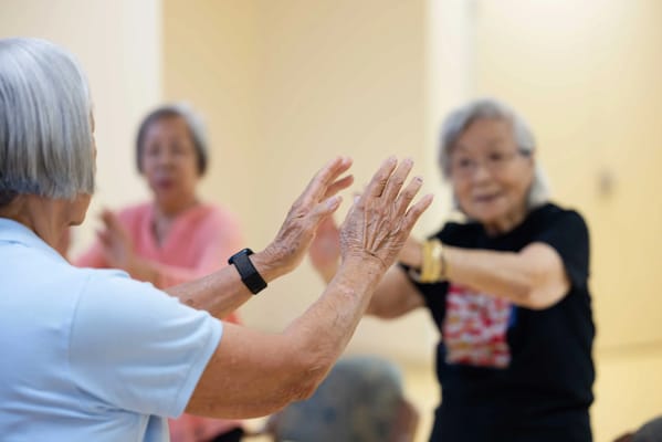 Residents participating in a movement activity class indoors.