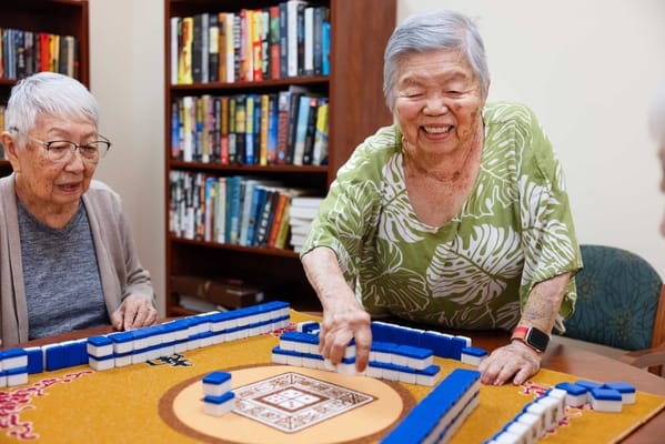 Residents enjoying a game of Mahjong in a cozy common area