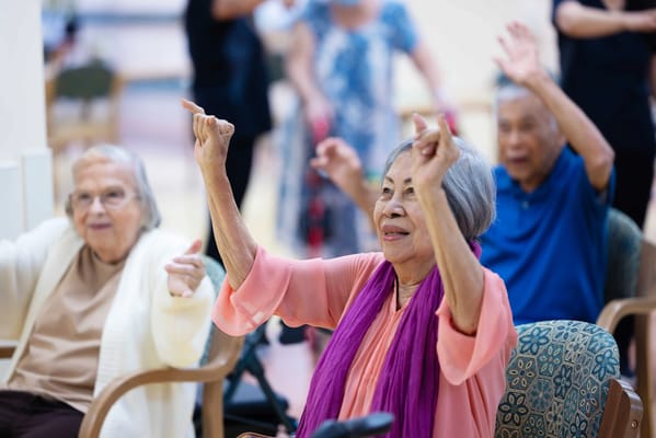 Residents engaged in an activity with staff in a bright common area