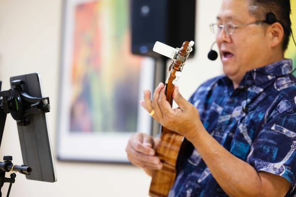 Man singing and playing ukulele during an activity
