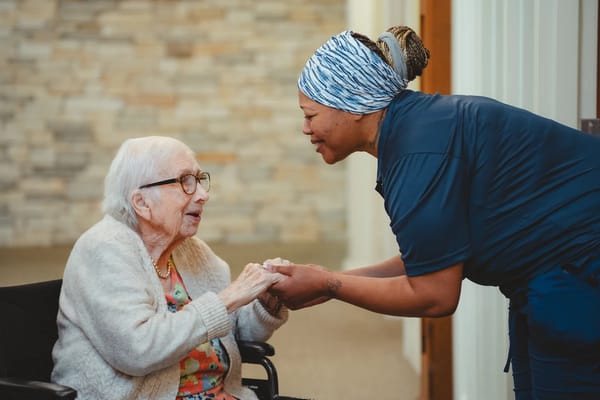 A staff member greeting a resident in a warm setting