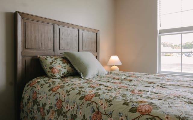 Cozy resident room with floral bedding and lamp