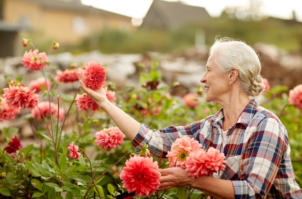 Senior resident enjoying flowers in a garden