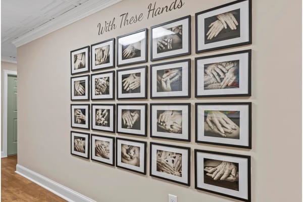 Gallery wall with framed black and white photos of hands