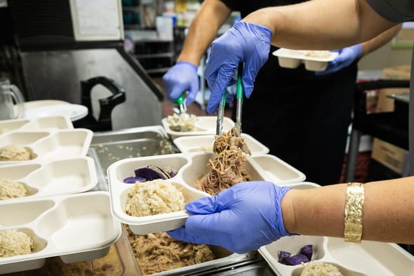 Staff serving meals in a kitchen setting