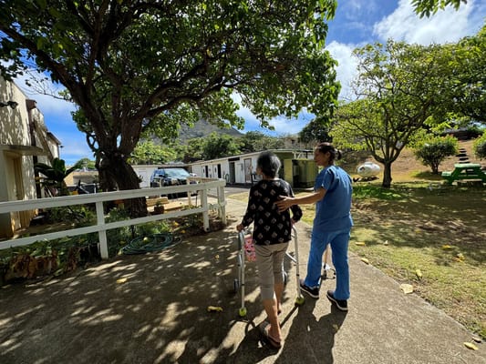 Staff assisting a resident in an outdoor area