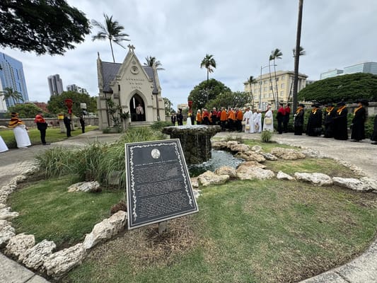 Commemoration event in a garden with participants in traditional attire