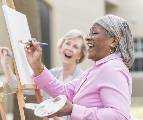 Residents enjoying a painting activity in the garden