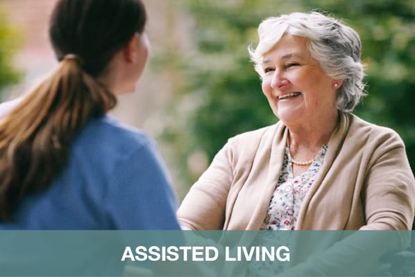 Resident enjoying conversation with staff outdoors
