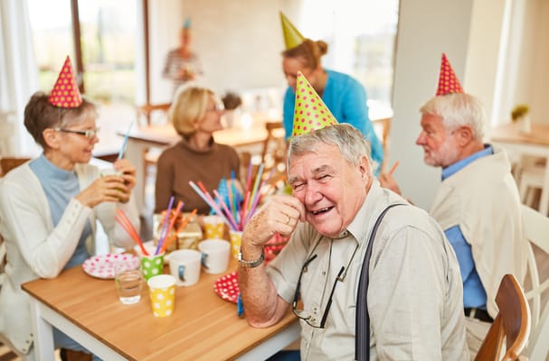 Residents celebrating with party hats in a common area