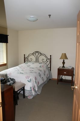 Cozy bedroom with a floral quilt and lamp