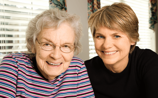Two women smiling together in a bright indoor setting
