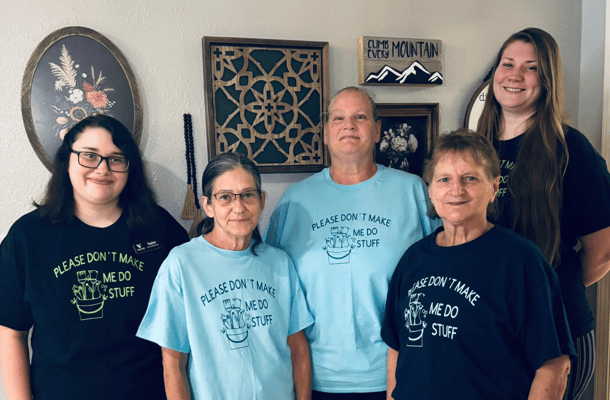 Staff and residents smiling together in a common area