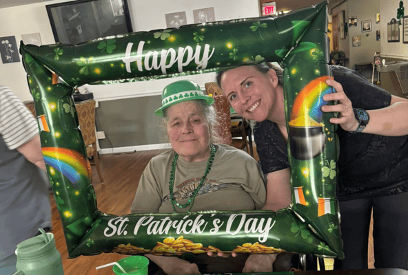 Resident celebrating St. Patrick's Day with staff member