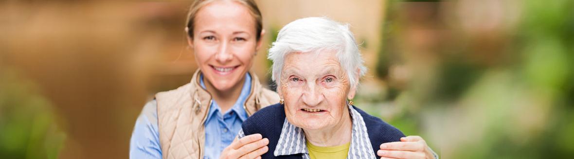 A caregiver assisting an elderly resident outdoors