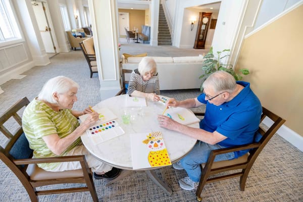 Residents engaged in an art activity at a table