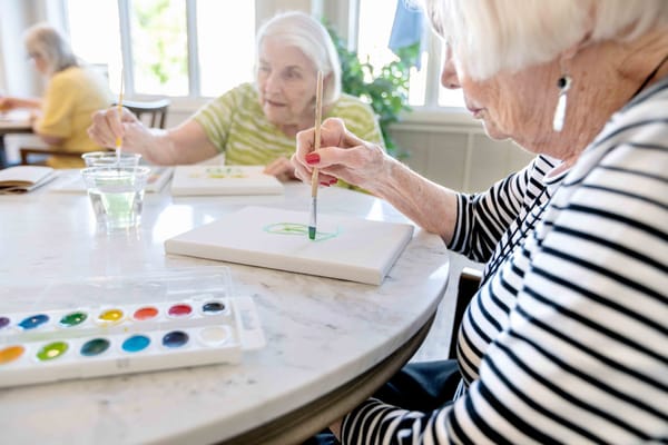 Residents painting at a round table during an activity session