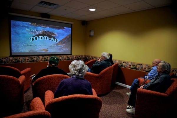 Residents enjoying a film in a cozy theater room