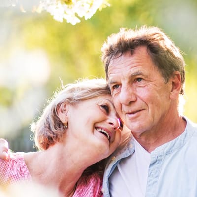 A smiling couple enjoying time outdoors in a natural setting