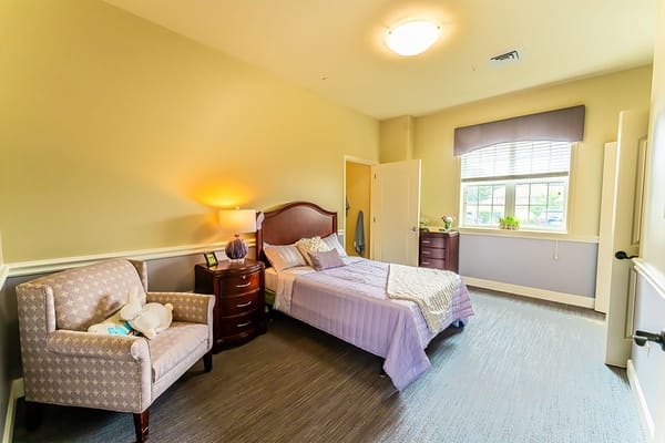 A well-furnished resident room with a bed and sitting area