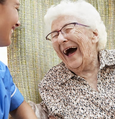 Caregiver laughing with a joyful resident