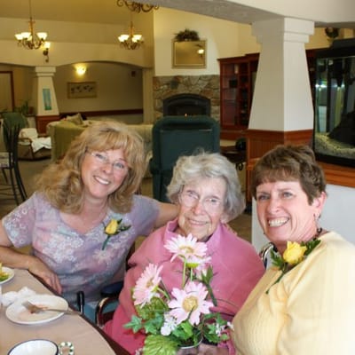 Residents and staff celebrating with flowers indoors