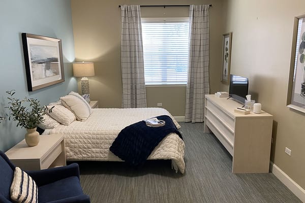 A well-furnished private resident room with a bed and decor
