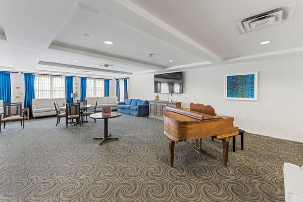 Interior view of a common area with a piano and seating