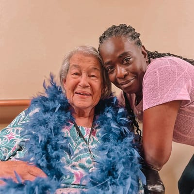 A resident and staff member smiling together