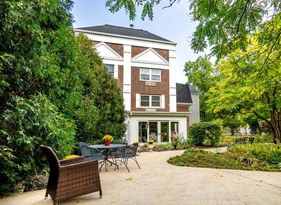 Exterior view of a building with outdoor seating and gardens