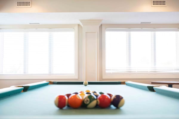 A pool table set up in a bright common area