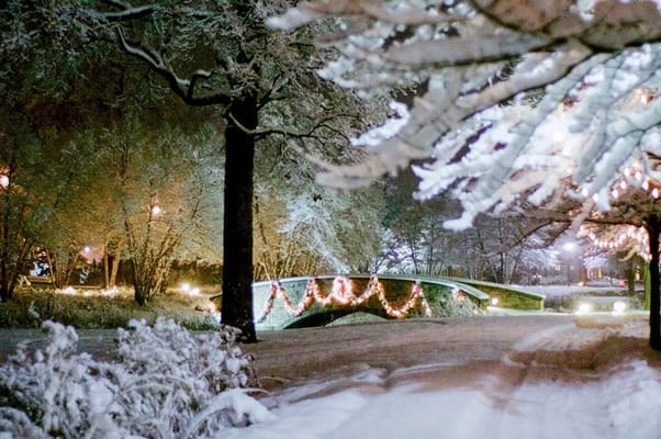 A winter scene of a snow-covered park bridge
